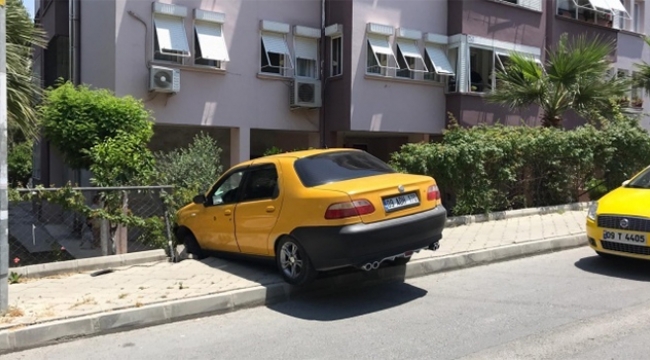 Otomobil site bahçesinin duvarında asılı kaldı