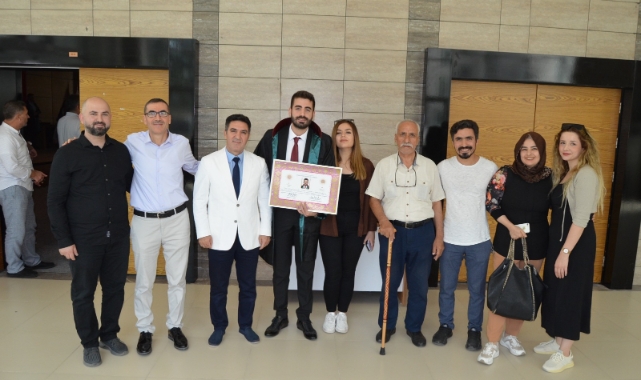 Oğlunun cübbesini giydirdi