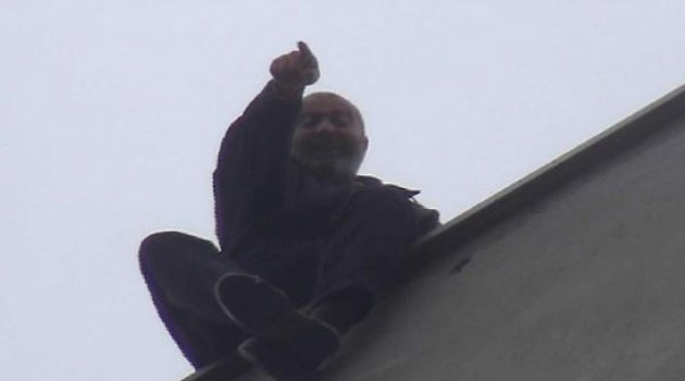 Oda aidat borcuna kızan kamyoncu çatıya çıktı