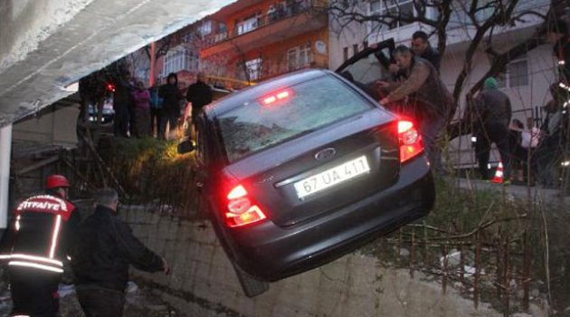 Otomobil duvarda askıda kaldı